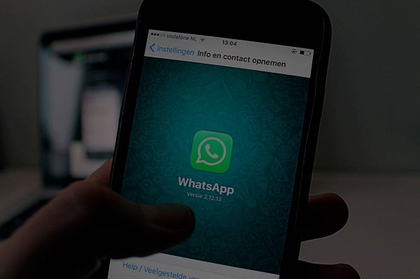 mexendo no celular com a tela aberta da logo marca whatsapp representando api link whatsapp